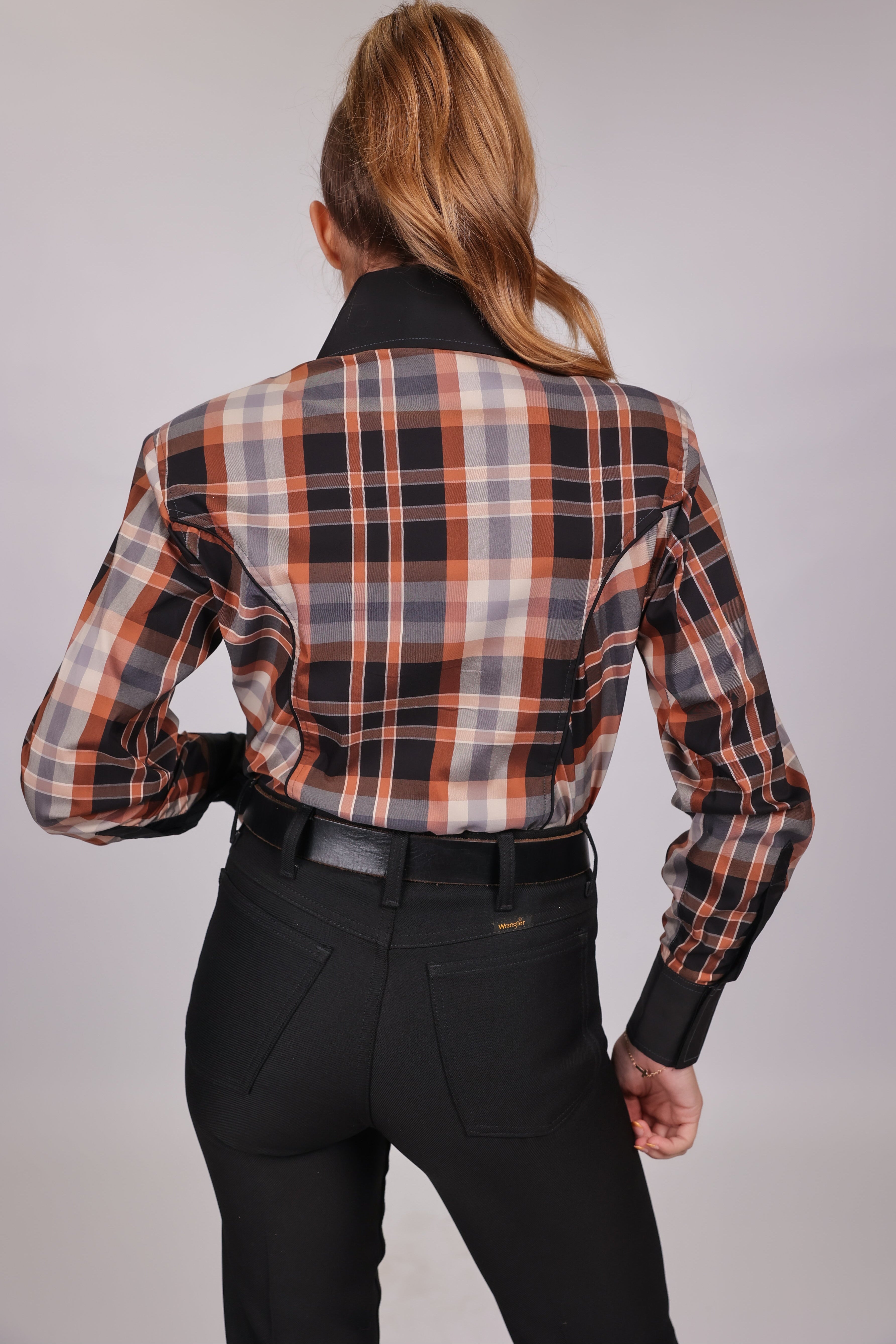 Model posing in plaid brown riding shirt from the Essentials collection by Kultured Rider, displaying the back