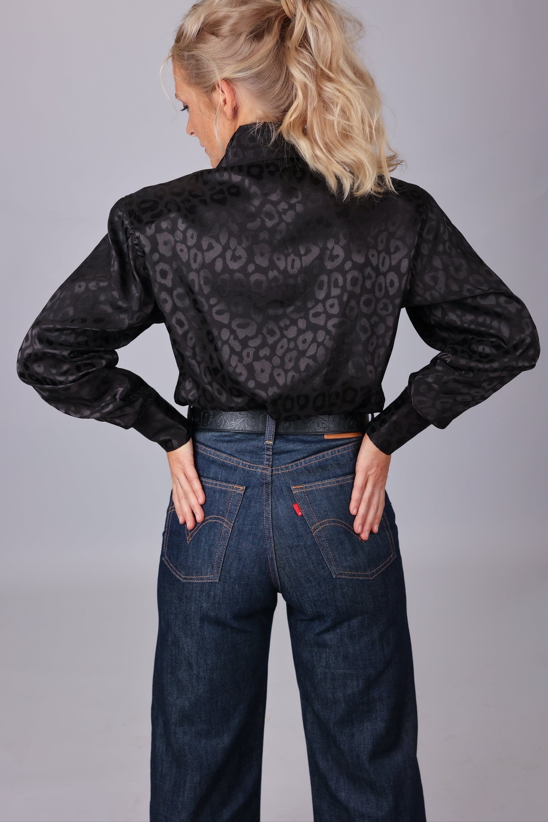 Model  posing in leopard black shirt from the Faith collection by Kultured Rider in a studio setting.