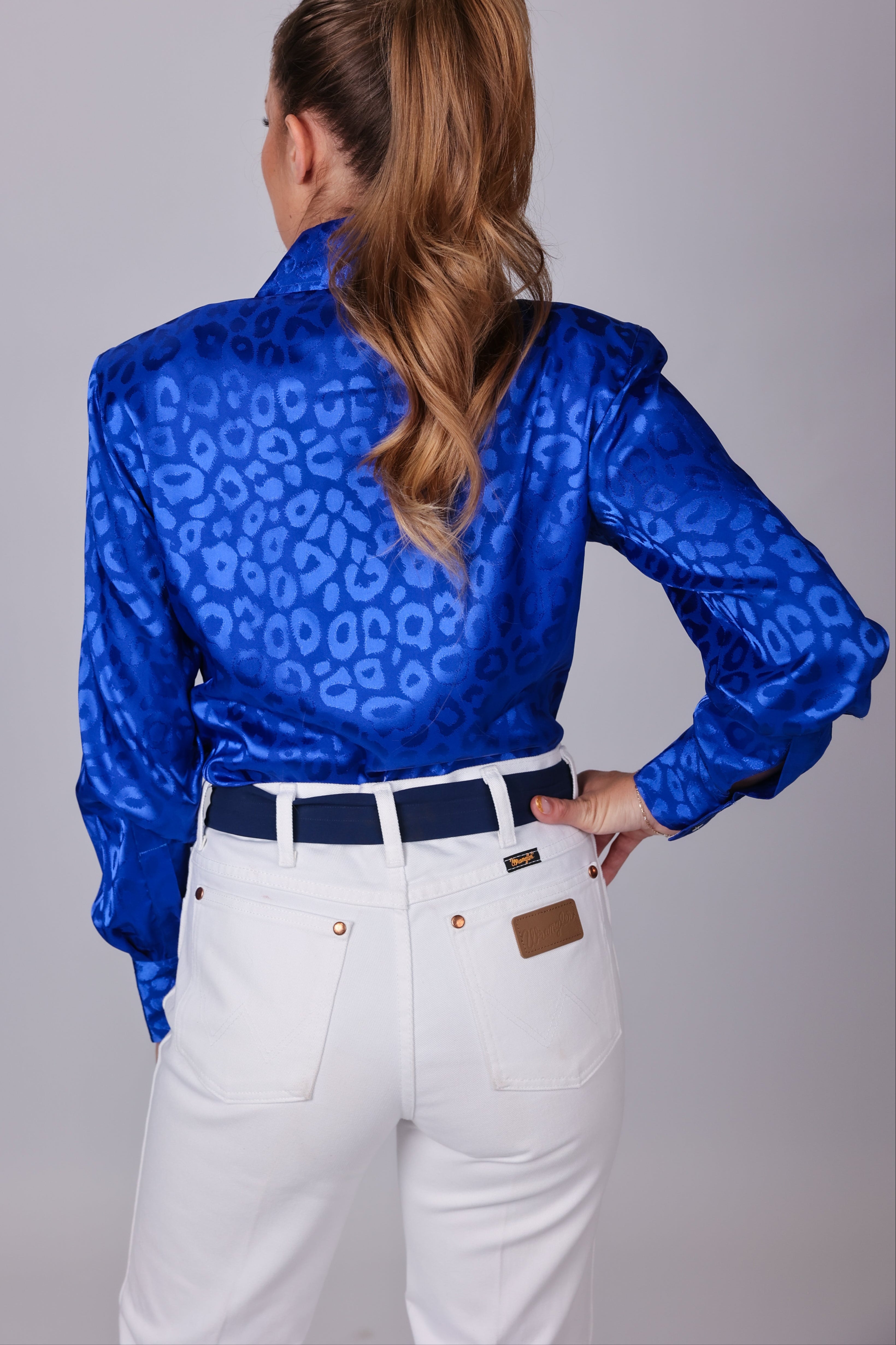 Model with horse posing in leopard blue shirt from the Faith collection by Kultured Rider in a studio setting.