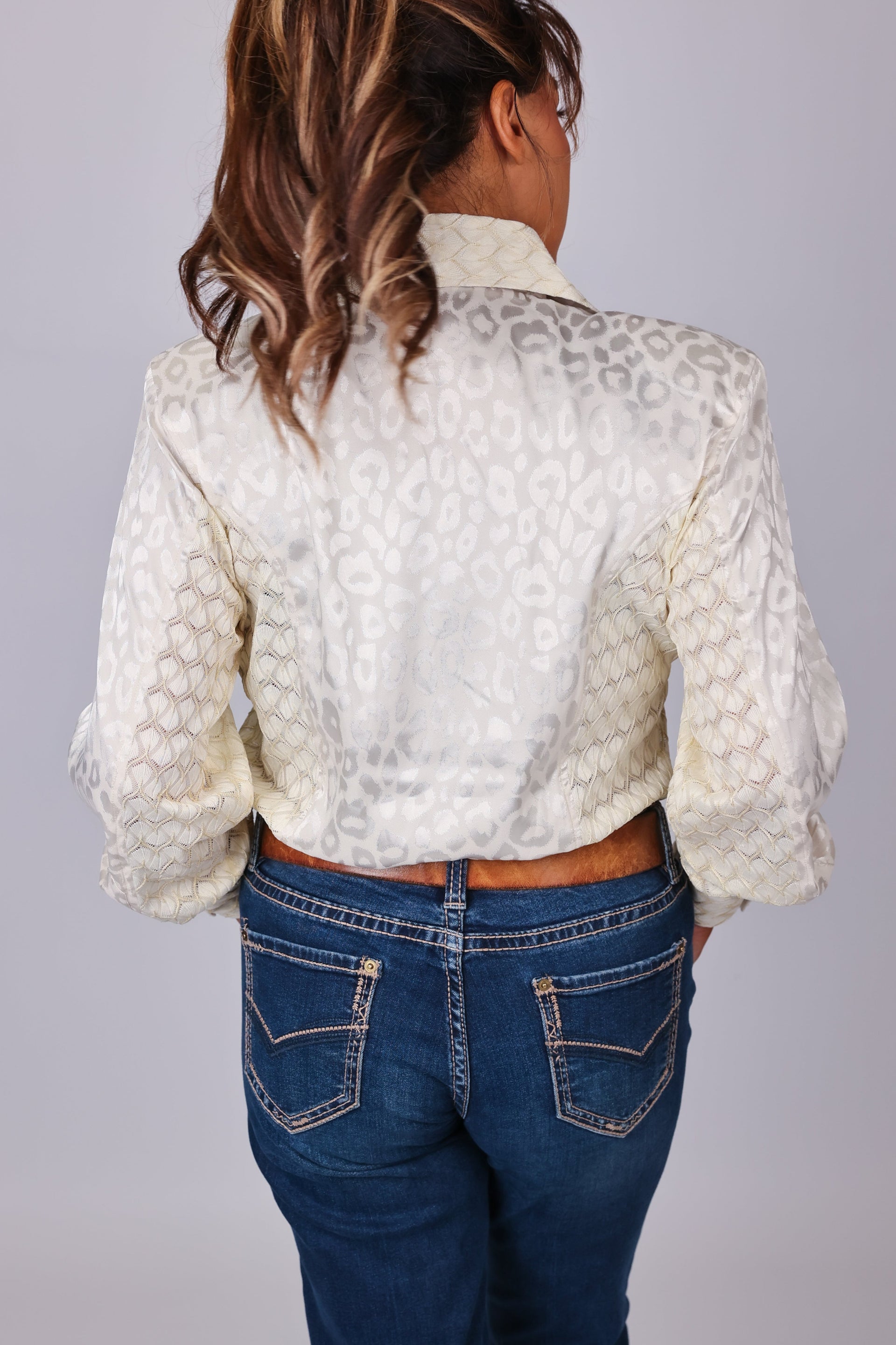 Model with horse posing in white lace shirt from the Faith collection by Kultured Rider in a studio setting.