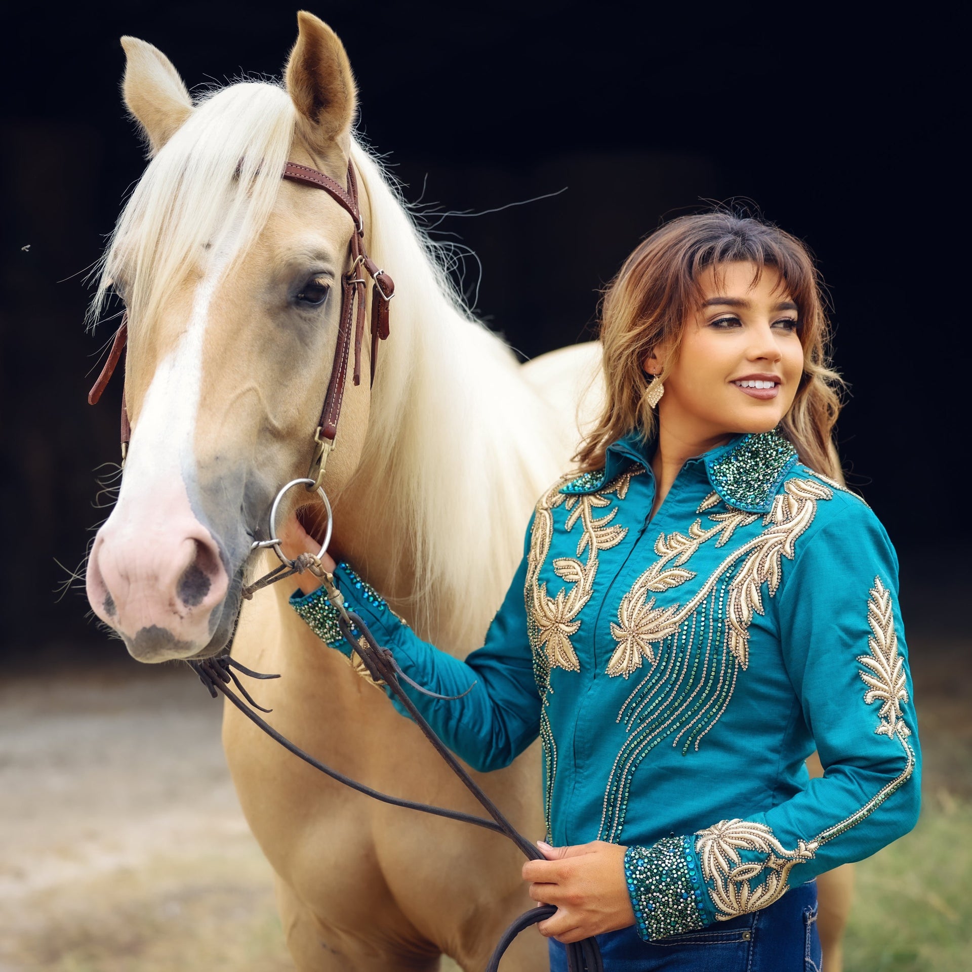 Model posing with horse in emerald and gold jacket by Kultured Rider