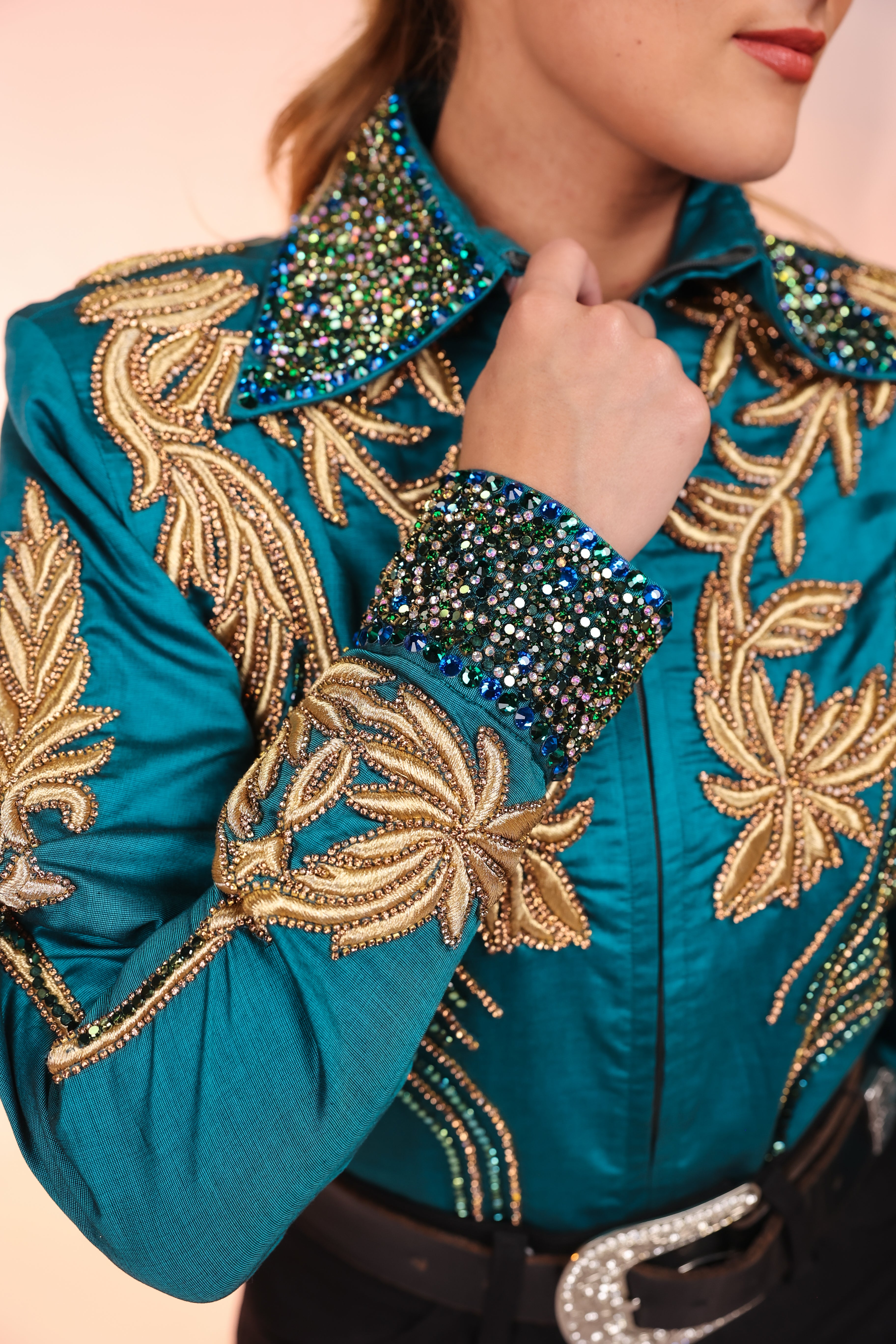 Model displaying collar details of emerald and gold Jacket by Kultured Rider