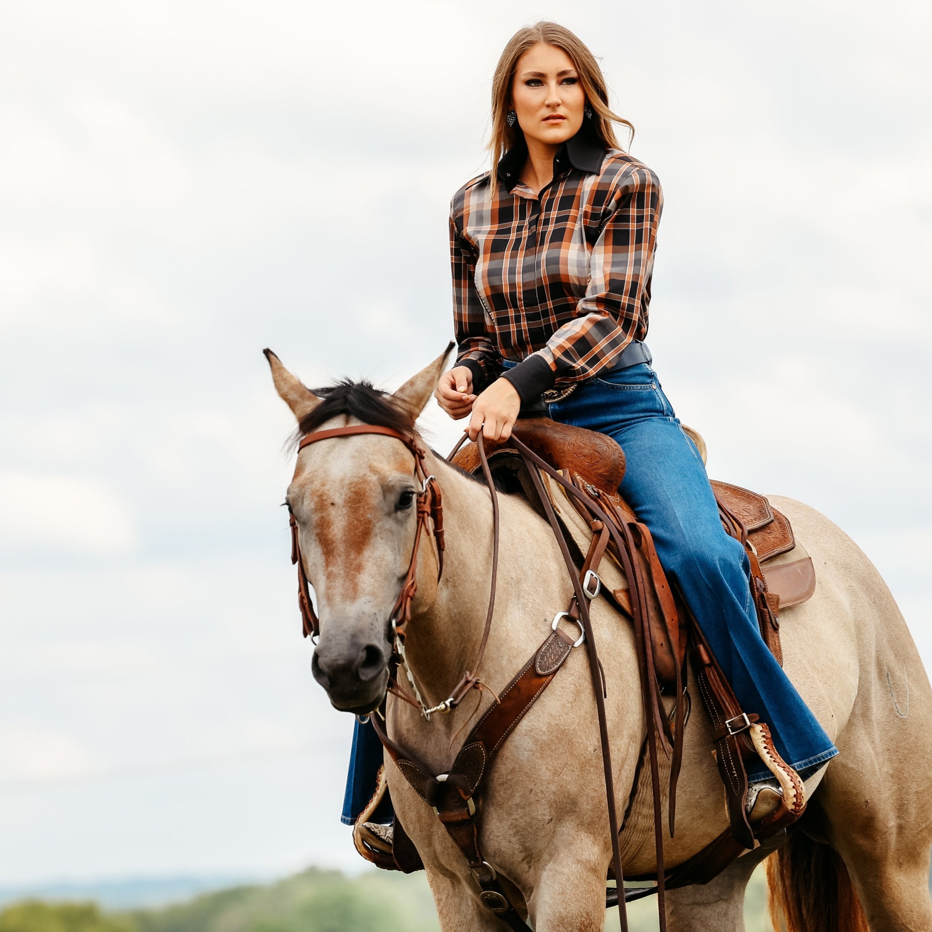 Model on horse posing in plaid brown riding shirt from the Essentials collection by Kultured Rider