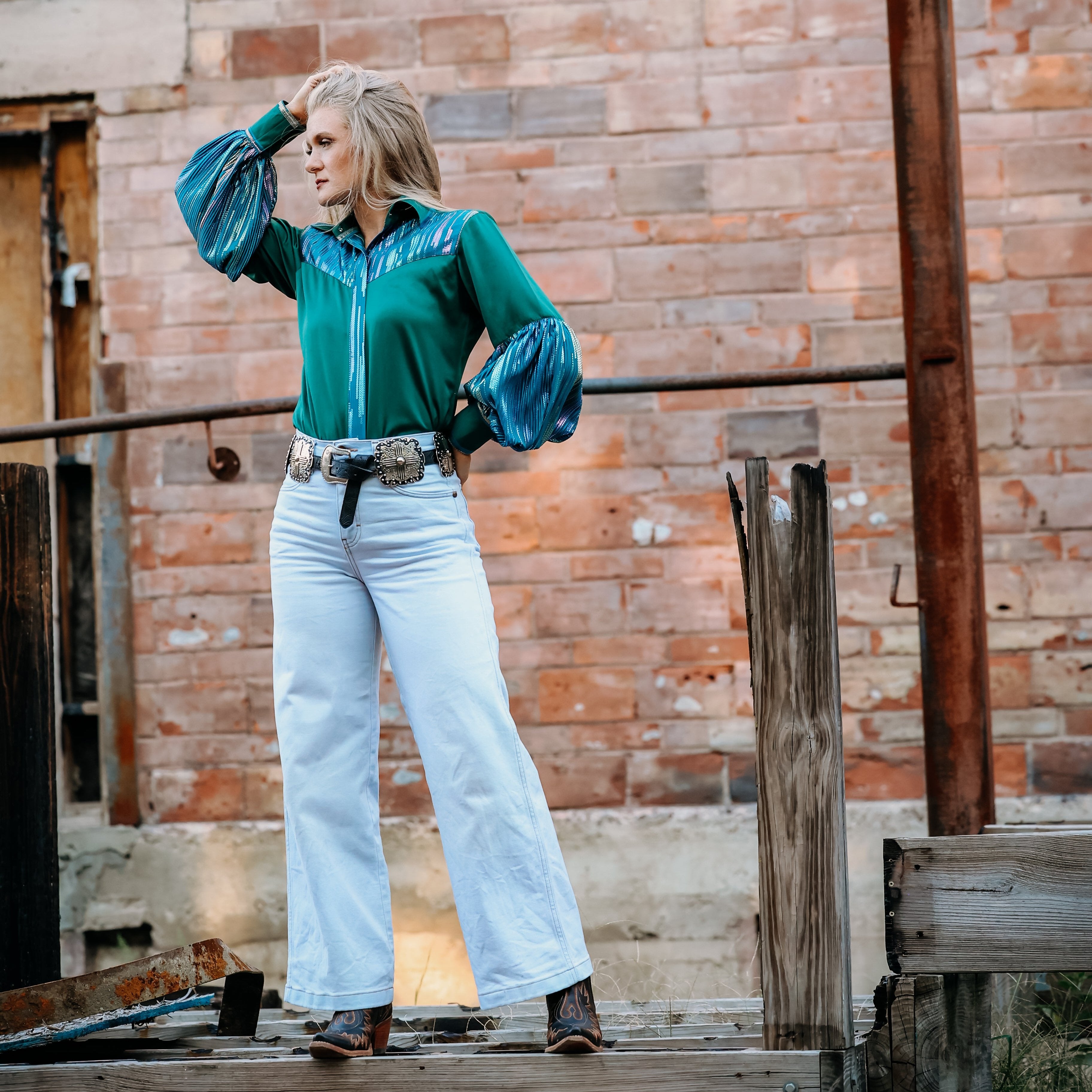 Model posing in front of brick wall with Spankol Green shirt by Kultured Rider