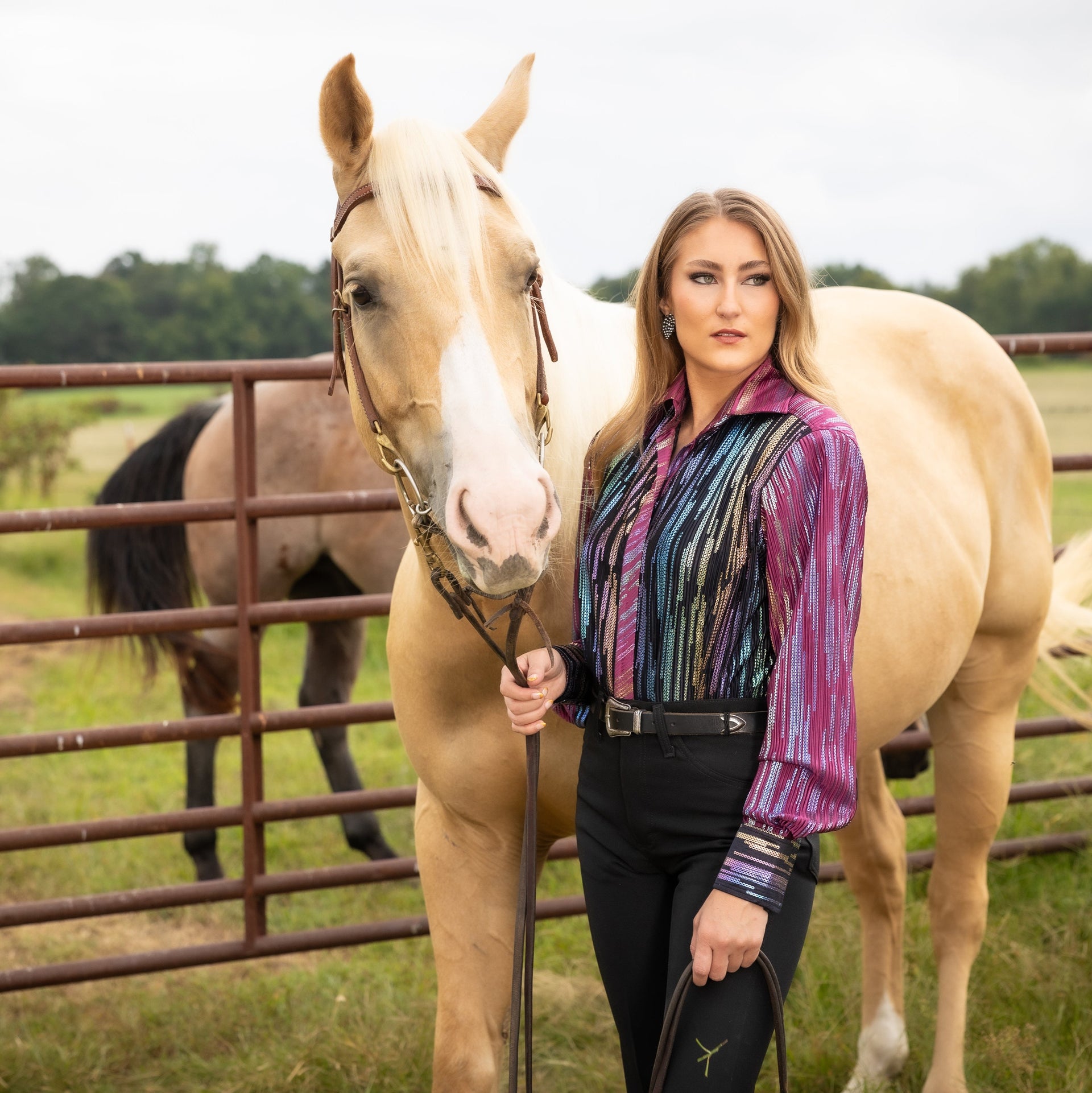 Model posing with horse in front of cattle fence with Spankol PInk & Black shirt by Kultured Rider