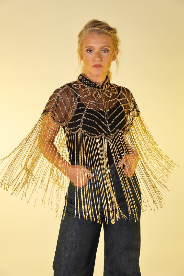 Model in gold vest by Kultured rider posing in studio setting