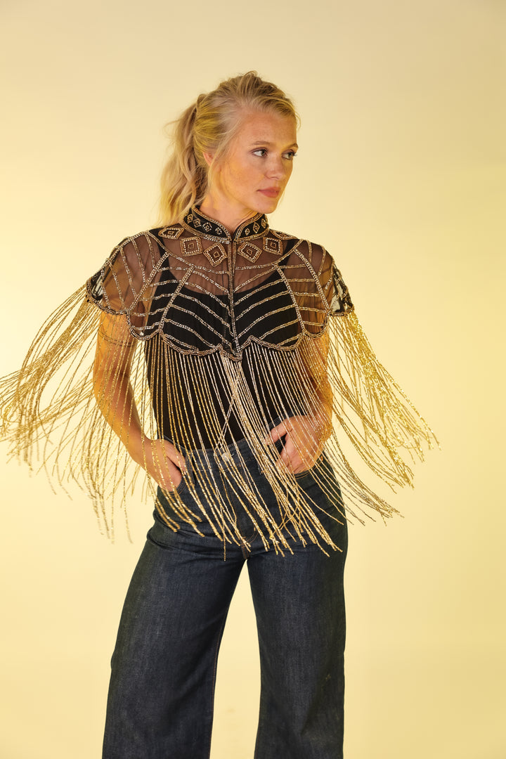 Model in gold vest by Kultured rider posing in studio setting