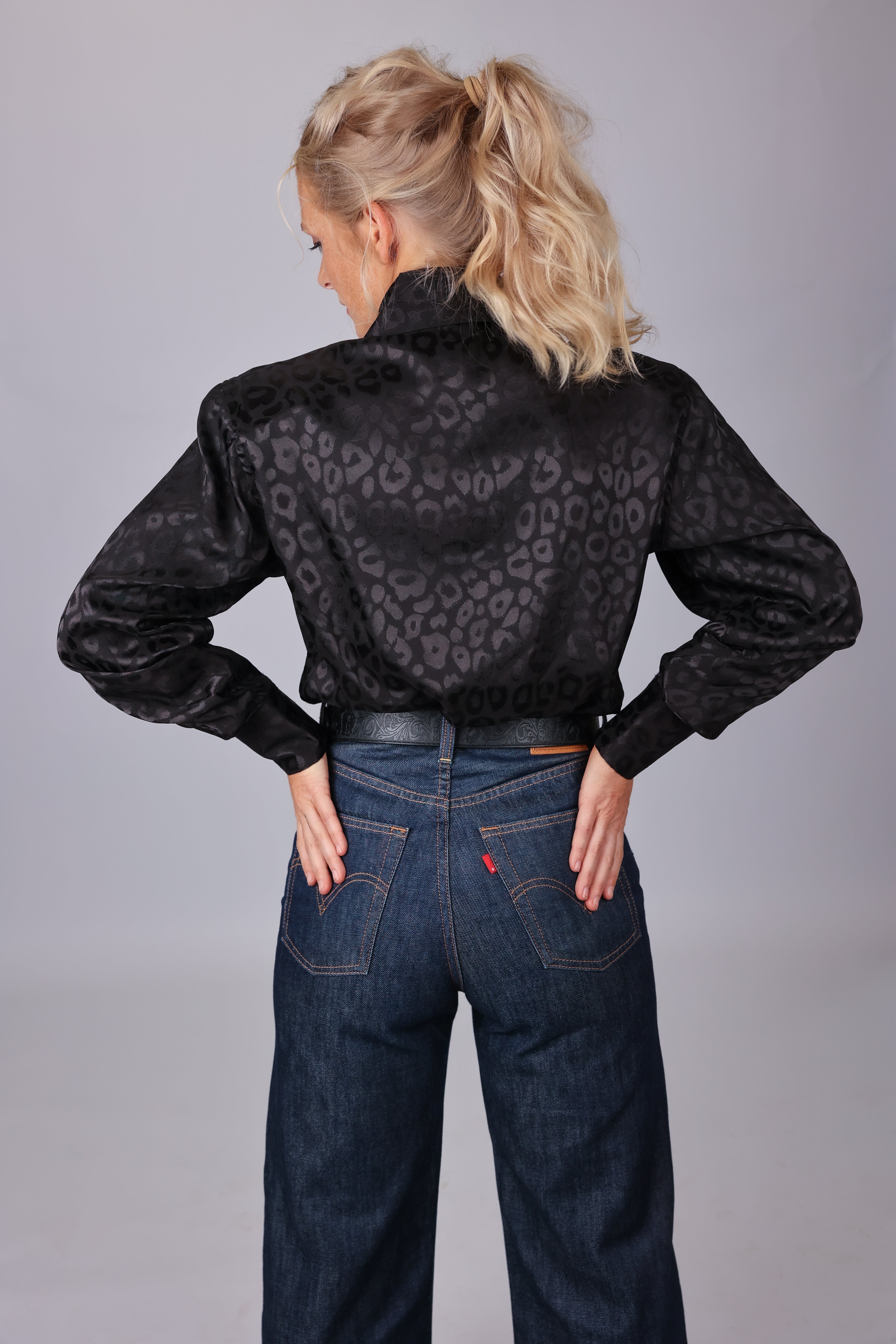 Model  posing in leopard black shirt from the Faith collection by Kultured Rider in a studio setting.