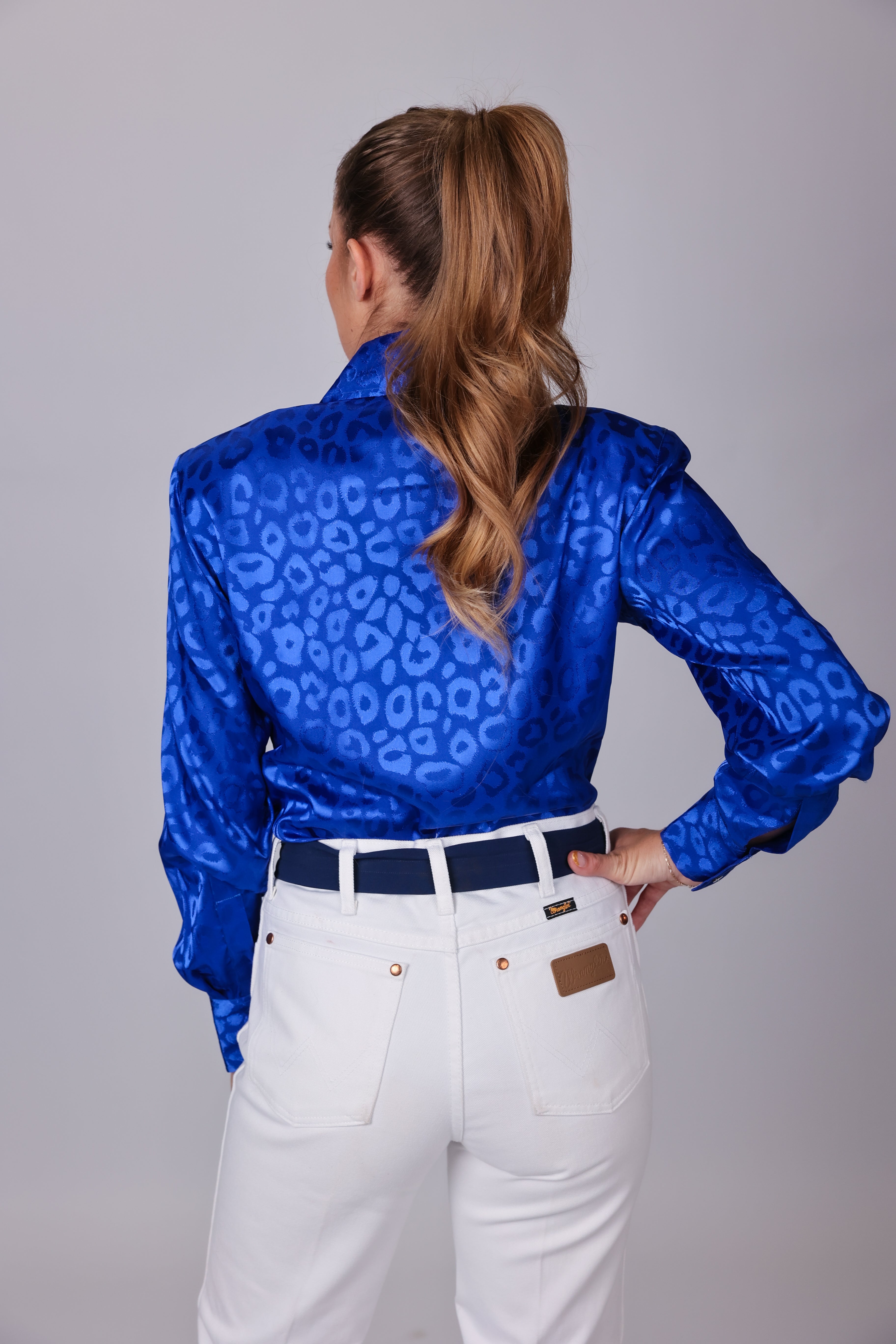 Model with horse posing in leopard blue shirt from the Faith collection by Kultured Rider in a studio setting.