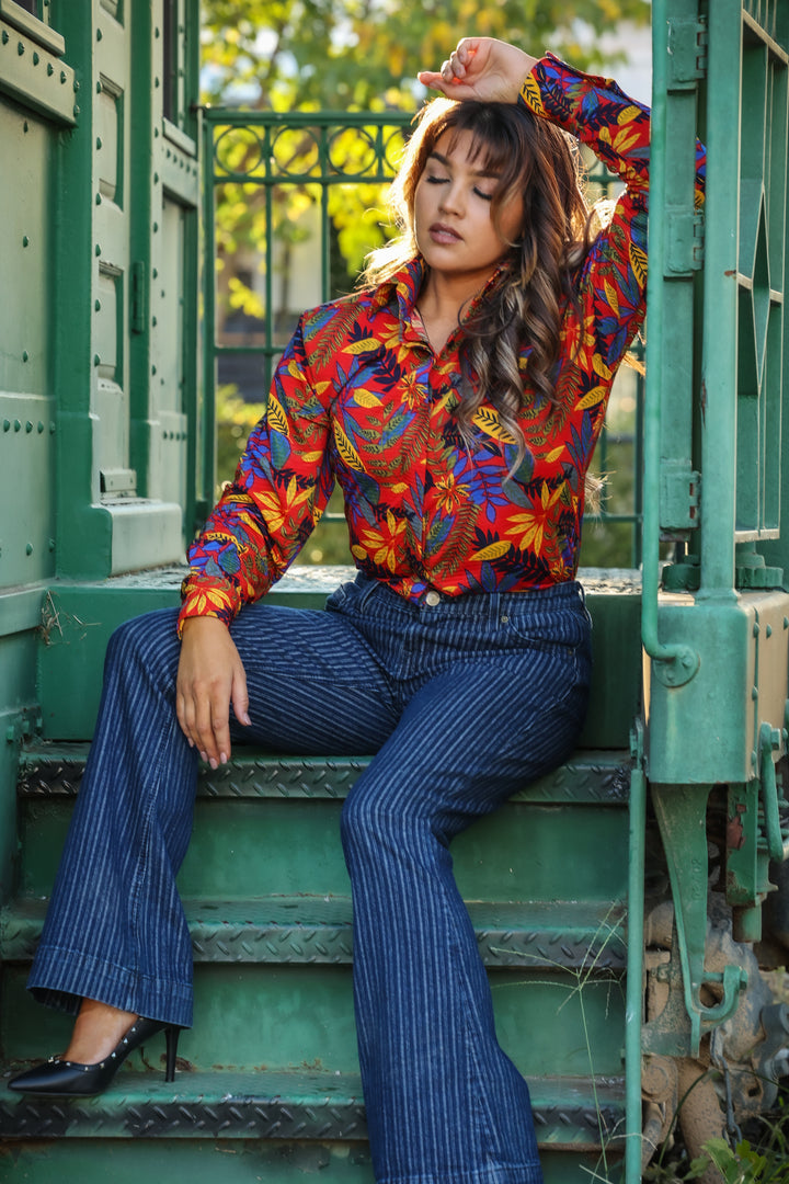 Model posing in jungle red shirt from the Romina collection by Kultured Rider in front of an urban backdrop.